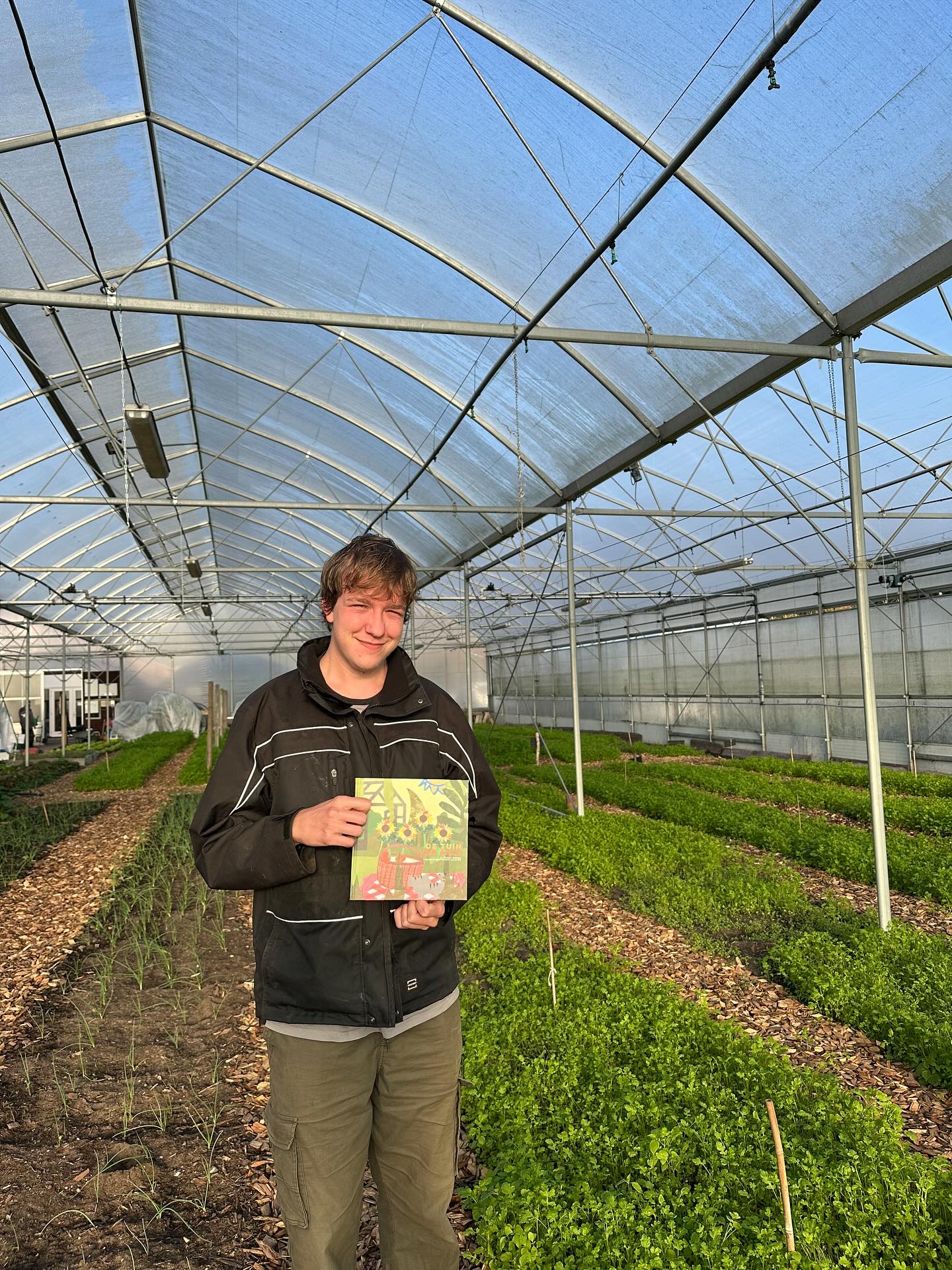 Een van de makers met het boek De Tuin van Kaat